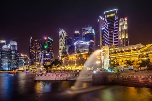Dazzling view of the Singapore cityscape with Merlion and illuminated skyscrapers at night.
